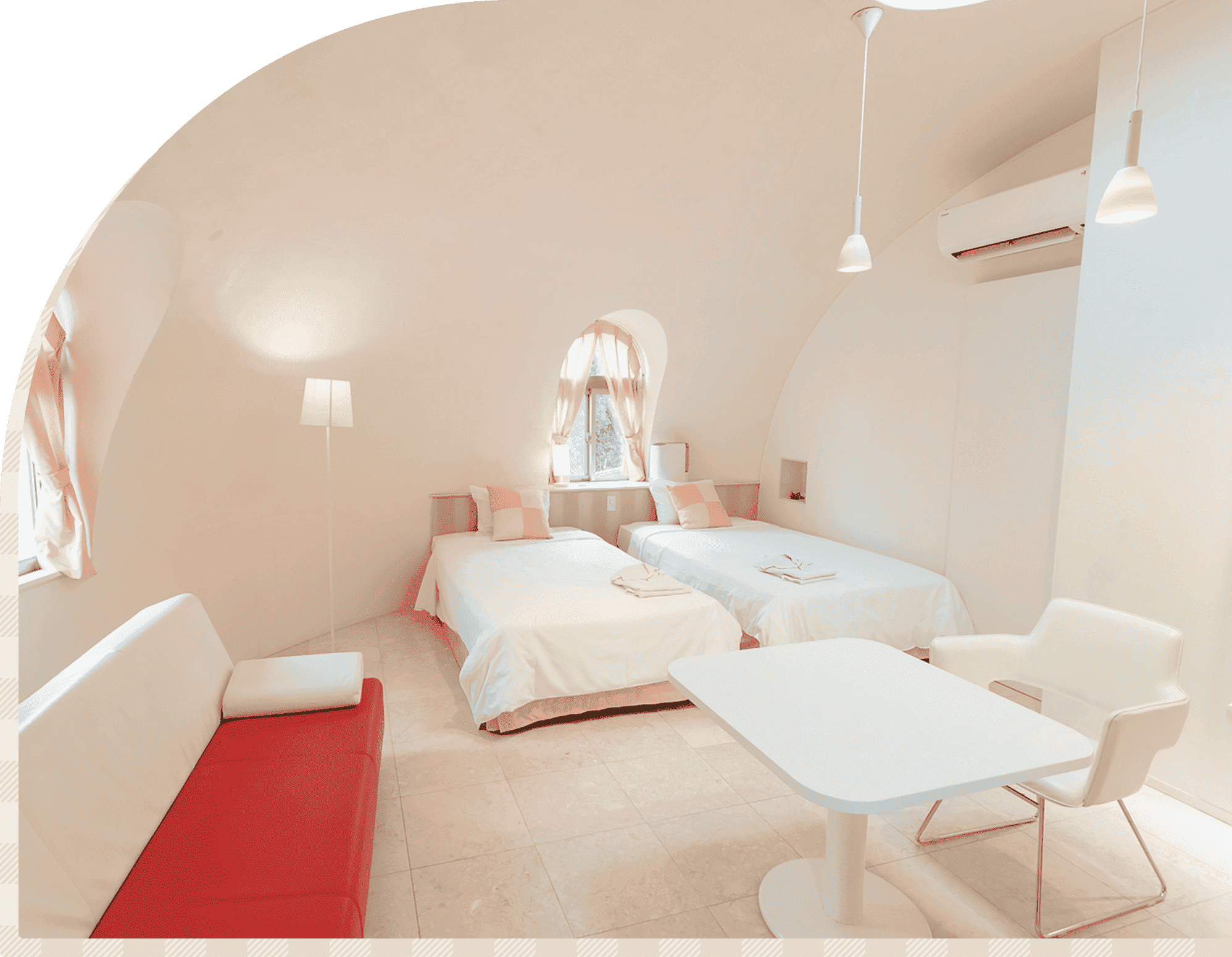 とれとれヴィレッジのドーム型客室。白を基調とした室内にツインベッドとテーブルを備えた空間