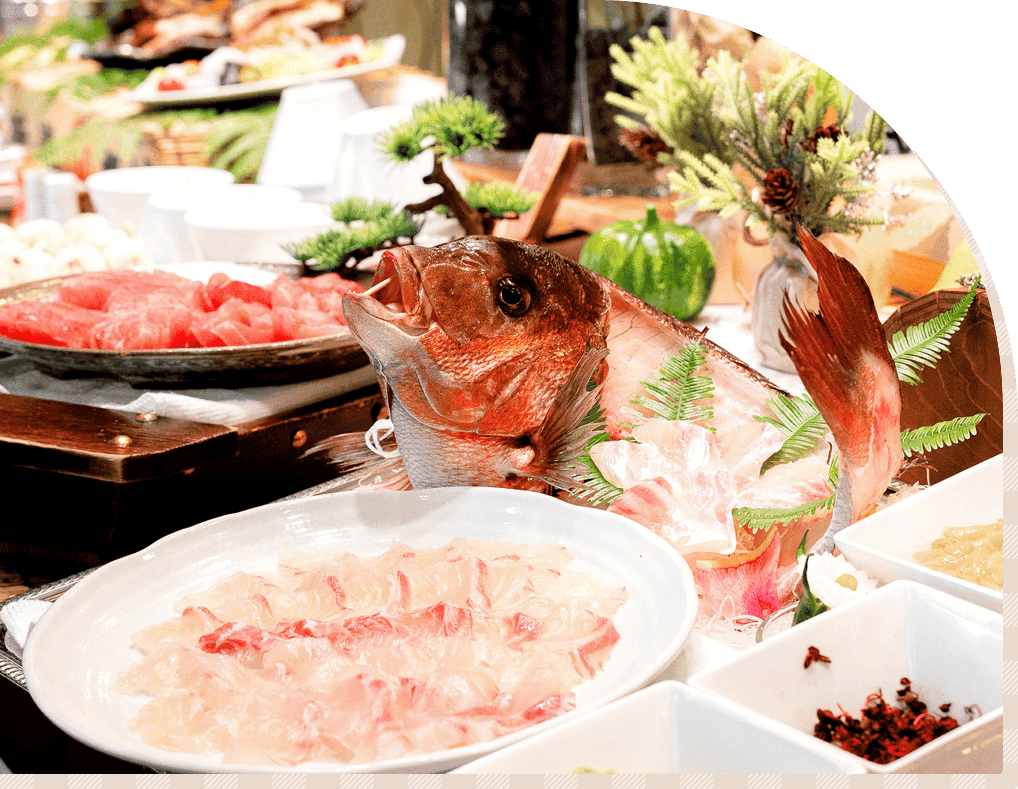 新鮮な魚を使った刺身が並ぶ食事の一例。鯛の姿造りを中心に盛り付けられている