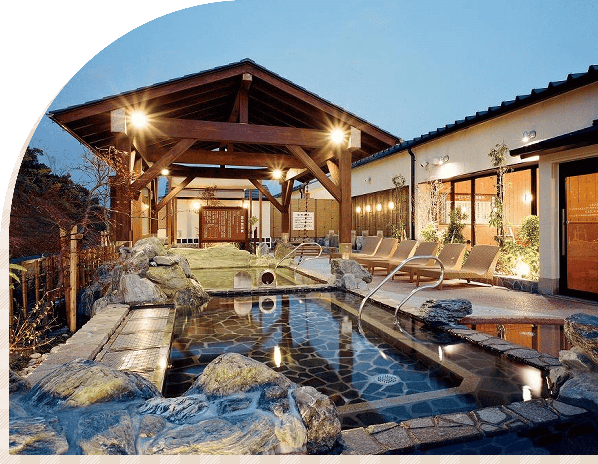 岩に囲まれた露天風呂と休憩スペースを備えた温泉施設の様子